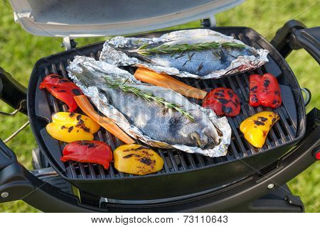Fresh dorado fish and bell pepper grill cooking outdoors