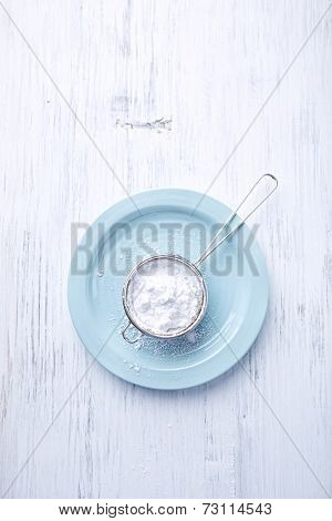 Sieve with icing sugar on a palte