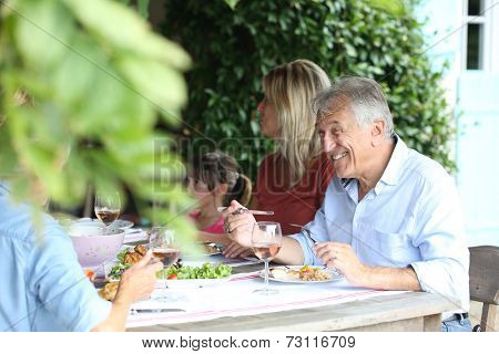 Family having summmer lunch in country house