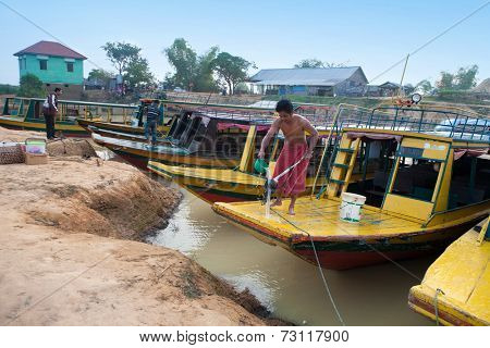 CAMBODIA- DEC 29  A man washing his mop for cleaning his passenger boat at Tonle Sap lake, Cambodia 29 December 2013