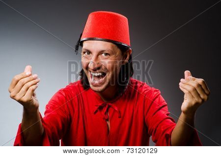 Man in red dress wearing fez hat