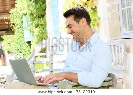 Mature man on week-end working from home with laptop