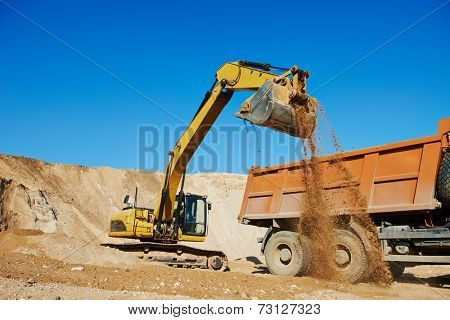 wheel loader excavator machine loading dumper truck at sand quarry