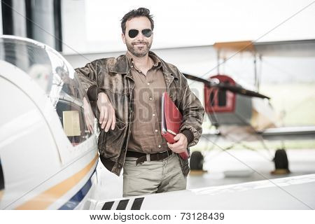 Pilot standing next to his airplane