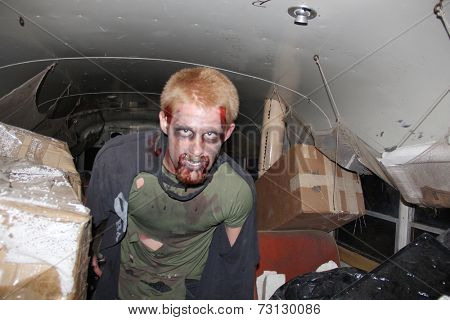 MUSKOGEE, OK - Sept. 13: Bloodied zombie comes from the dark to enter a school bus during the Castle Zombie Run at the Castle of Muskogee in Muskogee, OK on September 13, 2014. 