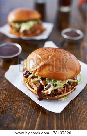 barbecue pulled pork sandwiches with cole slaw on wood table