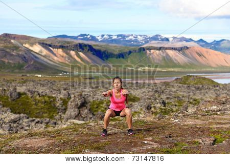 Fitness girl exercising outdoors doing jump squat in amazing nature landscape. Fit female woman athlete cross-training outside. Image from Iceland.