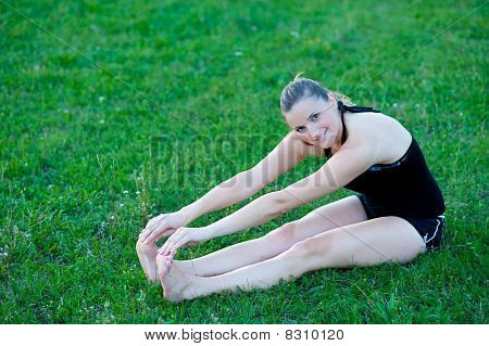 Cute adolescente s'étend ses jambes sur une grasss vert