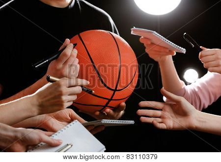 Autographs by basketball star on black and lights background