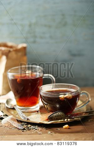 Beautiful vintage composition with herbal tea, on wooden table
