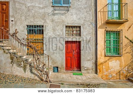 Facade of typical italian house with colorful windows and doors in town of Saluzzo in Piedmont, Northern Italy.