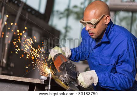 Worker Grinding Metal With Angle Gringer