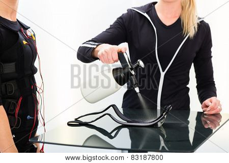 Female coach prepare ems electro muscular stimulation costume 