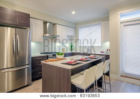 Modern kitchen interior with island and cabinets in a luxury house set for dinner