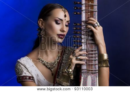 Beautiful Indian Woman In Sari With Oriental Jewelry Playing The Sitar