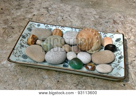 Seashell, pebbles and gemstones on the plate