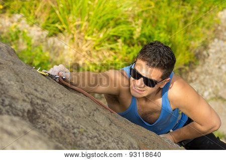 man climbing mountain with sunglasses