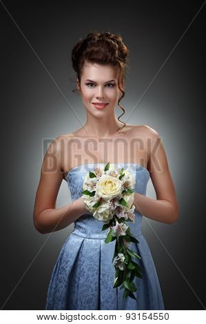 Studio Portrait Of A Beautiful Bride In A Blue Dress With A Bouquet Of Roses And Orchids.