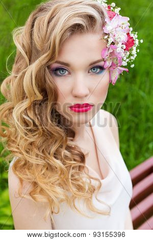 beautiful tender sweet girl in a white dress with a wedding hairdo curls bright makeup and red lips