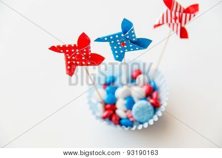 american independence day, celebration, patriotism and holidays concept - close up of glazed sweet candies with pinwheel toys decoration at 4th july theme party