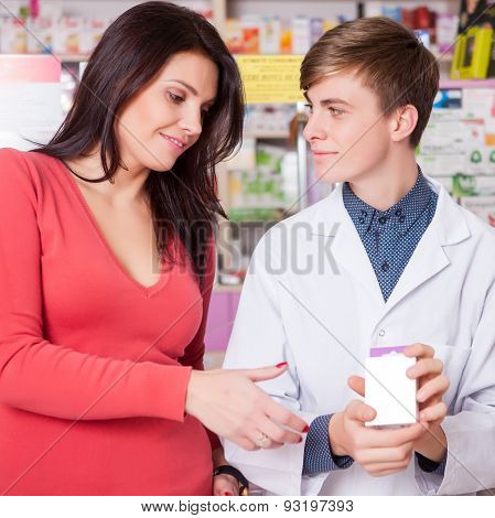 Typical Situation In Pharmacy Doctor Showing Packege To Client