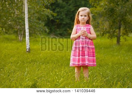 Child holding glass water. Girl at summer