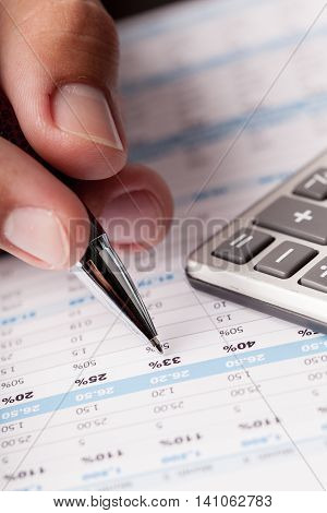 Close-up of a Businessman Analyzing Financial Figures with Calculator