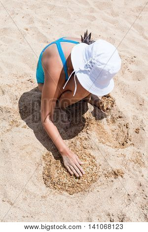 Tanned Girl In A White Hat Playing On The Beach