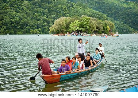 Pokhara Nepal - July 25, 2011: Tourists enjoy boat ride in vast Phewa Lake, natural colors. Phewa lake is a tourist spot located at an altitude of 742 m