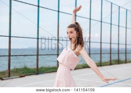 Happy amazed young woman balacing and having fun outdoors