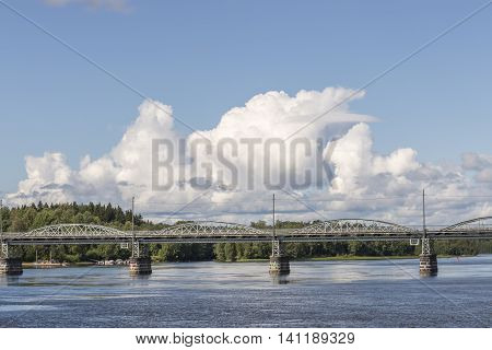 Bridge over River in Umea Sweden with a partly cloudy sky.