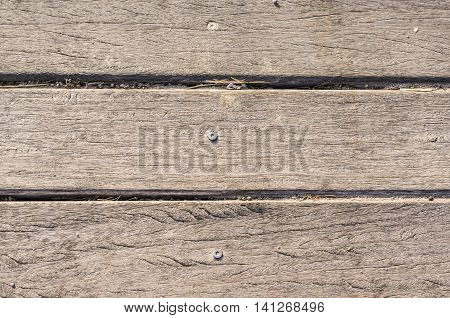 wooden slats with screw horizontally on the beach worn by the sun background