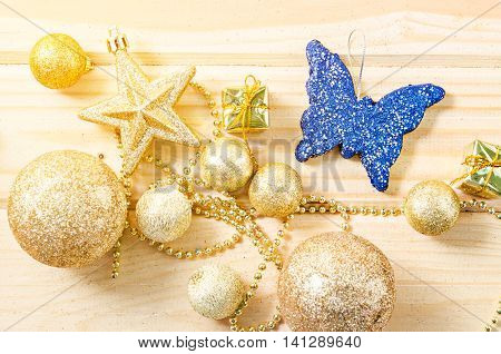 Gold theme color christmas decorations on wooden background with daylight.