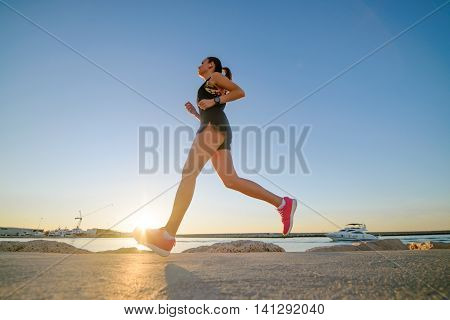 Young Sporty Girl Running Alone At Beautiful Sunset On The Beach