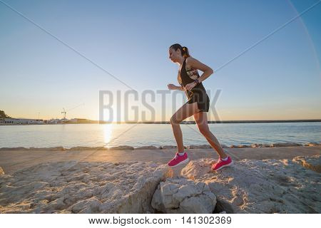 Young Sporty Girl Running Alone At Beautiful Sunset On The Beach