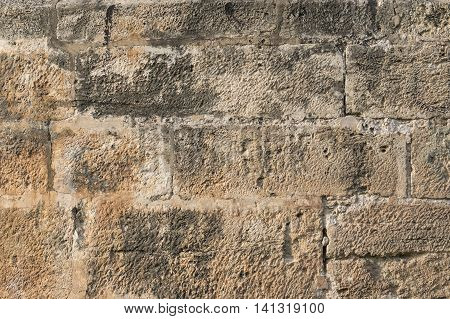 brown old wall of large pieces of stone as bricks rectangular gray background