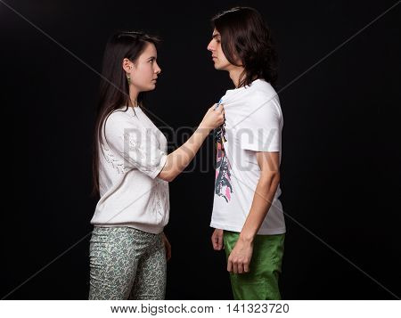 Family quarrel - woman is threatening the man black background