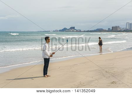 Young Fellow Using Selfie Stick At China Beach In Danang