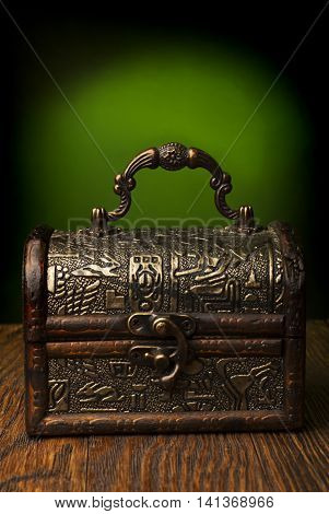 Very old chest in grunge interior  on a wooden background