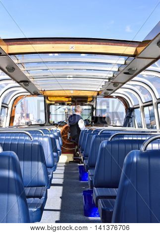 Indoors of a tourboat with blue seats.