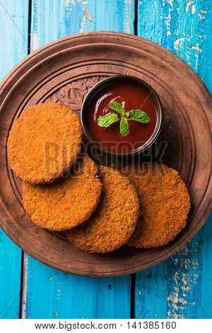 Indian chat item aloo or aalu tikki or tikiya or fried potato cake also known as ragda patties served with tomato ketchup, selective focus