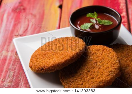 Indian chat item aloo or aalu tikki or tikiya or fried potato cake also known as ragda patties served with tomato ketchup, selective focus