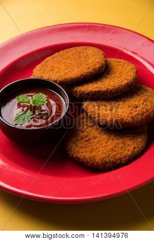 Indian chat item aloo or aalu tikki or tikiya or fried potato cake also known as ragda patties served with tomato ketchup, selective focus
