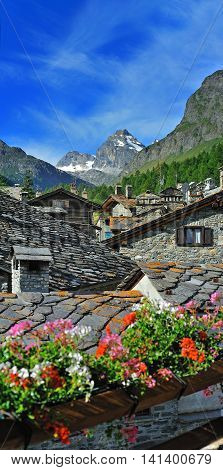 Old alps architecture with flowers in town in Rhemes Notre Dame Valle d'Aosta Italy