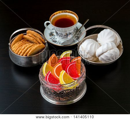 Tea time with old fashioned candies and cookies in vintage bowls. Selective focus shallow dof.