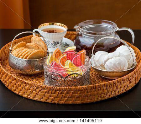Tea time with old fashioned candies and cookies in vintage bowls. Selective focus shallow dof.