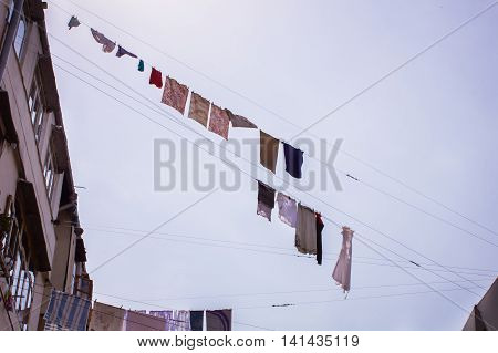 A group of primary colored t-shirts on a clothesline in front of blue sky