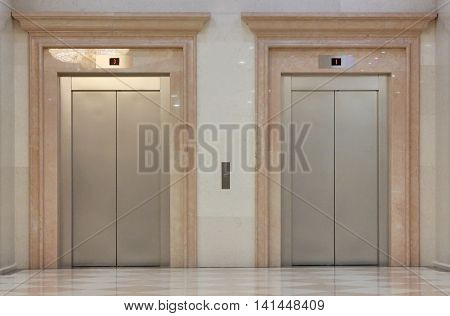 Two closed elevators in the shiny building
