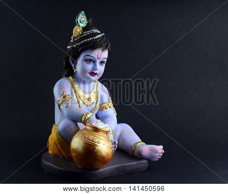 Hindu God Krishna. Statue of God Krishna on dark background