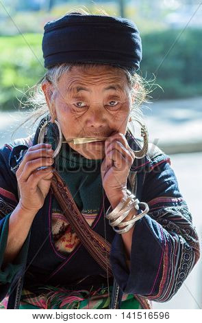 Sapa Lao Cai Province Vietnam - November 25 2014: Hmong old woman at a dan moi and wearing traditional attire in Sapa town on November 25 2014 Lao Cai Province North Vietnam.